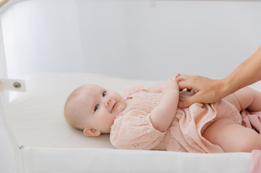 Baby girl laying in a bassinet
